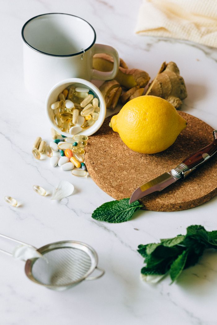 Home A flat lay of natural ingredients and supplements featuring lemon, ginger, and pills.